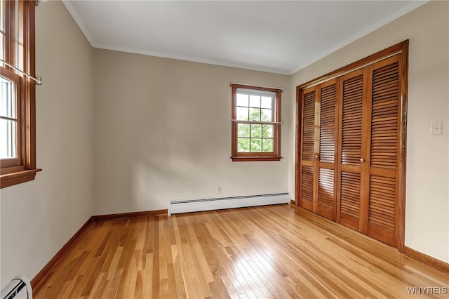 218 Hall Rd, Lancaster, NY 14059 - unfurnished bedroom featuring baseboard heating, a baseboard radiator, light wood-style flooring, a closet, and ornamental molding