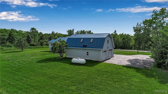 11131 Harlow Rd, Darien, NY 14004 - view of side of home featuring a gambrel roof, an attached garage, a metal roof, driveway, and a lawn