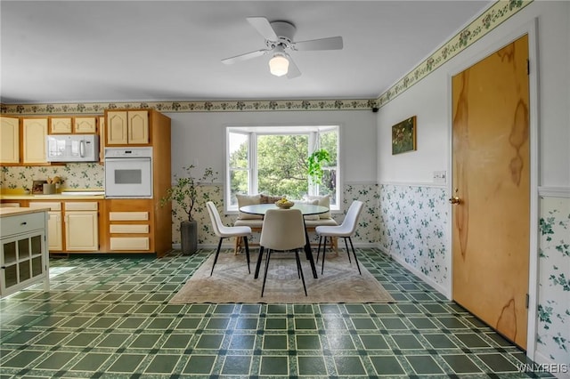 11131 Harlow Rd, Darien, NY 14004 - dining space featuring dark flooring, wallpapered walls, and ceiling fan