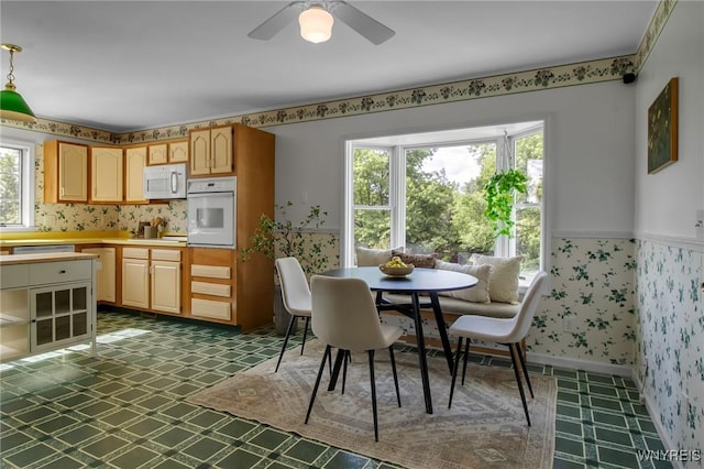 11131 Harlow Rd, Darien, NY 14004 - dining space with wallpapered walls, a ceiling fan, and dark floors