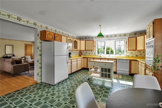 11131 Harlow Rd, Darien, NY 14004 - kitchen featuring white appliances, wallpapered walls, dark flooring, light countertops, and glass insert cabinets