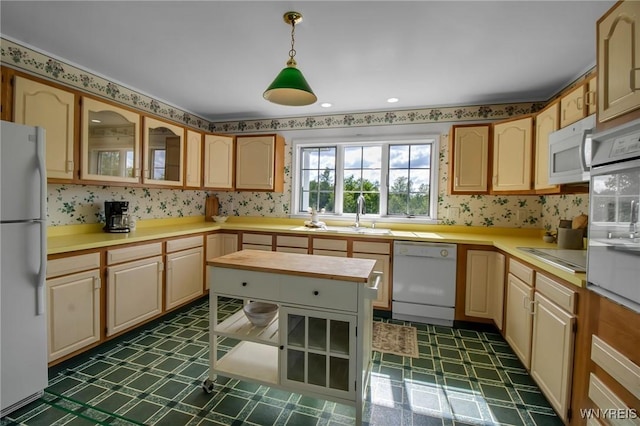 11131 Harlow Rd, Darien, NY 14004 - kitchen featuring white appliances, dark flooring, light countertops, hanging light fixtures, and glass insert cabinets