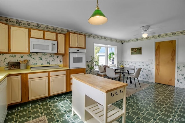 11131 Harlow Rd, Darien, NY 14004 - kitchen with white appliances, dark floors, hanging light fixtures, ceiling fan, and wallpapered walls