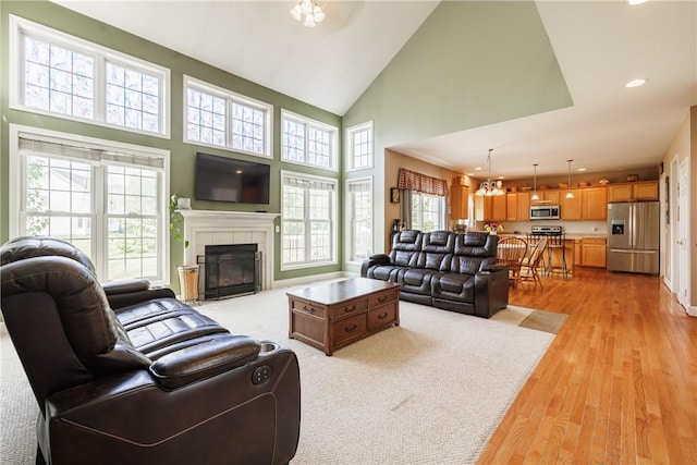 16 Hepburn Ln, Pittsford, NY 14534 - living room with high vaulted ceiling, light wood-style floors, a fireplace, a chandelier, and recessed lighting