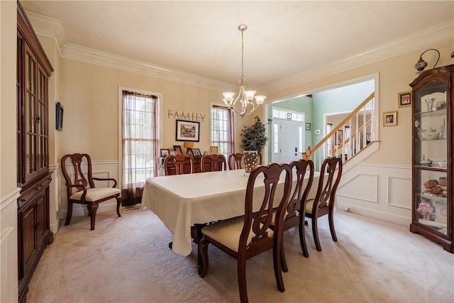 16 Hepburn Ln, Pittsford, NY 14534 - dining area featuring light colored carpet, a decorative wall, crown molding, a chandelier, and wainscoting