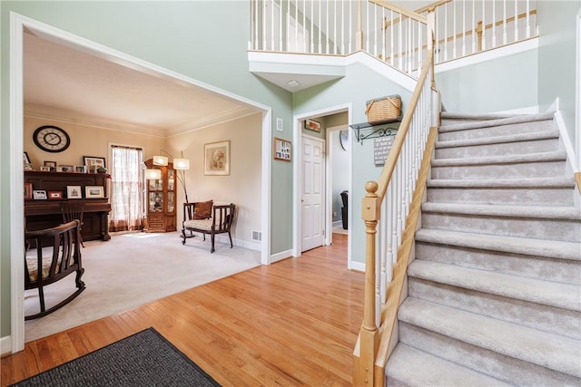 16 Hepburn Ln, Pittsford, NY 14534 - stairs with crown molding, wood finished floors, and a towering ceiling