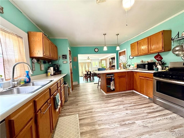 4935 N Jefferson St, Richland, NY 13142 - kitchen with stainless steel appliances, ceiling fan, a peninsula, brown cabinetry, and ornamental molding