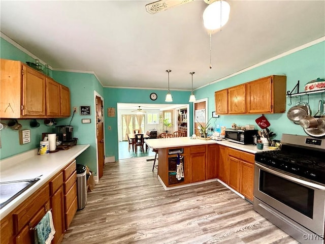 4935 N Jefferson St, Richland, NY 13142 - kitchen with appliances with stainless steel finishes, a peninsula, ornamental molding, light countertops, and brown cabinetry