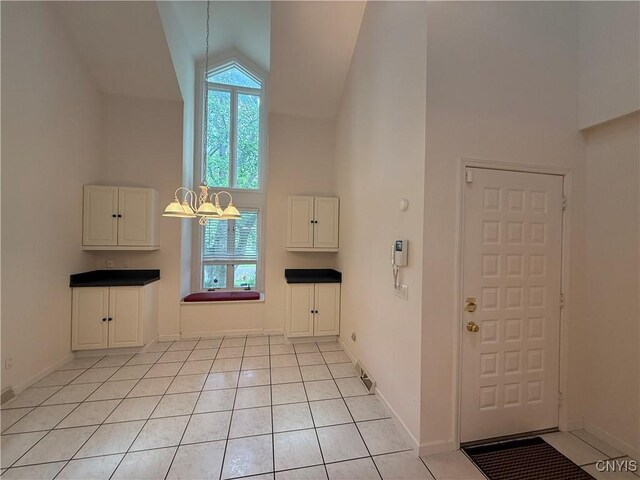 5326 Bunker Hill Way, Onondaga, NY 13207 - foyer entrance featuring high vaulted ceiling, a chandelier, healthy amount of natural light, and light tile patterned floors