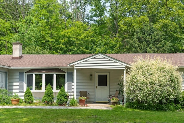 226 Academy St, Middletown, NY 12455 - view of front of property featuring a front lawn, a chimney, and a shingled roof
