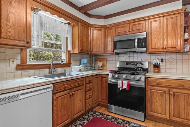 226 Academy St, Middletown, NY 12455 - kitchen featuring appliances with stainless steel finishes, brown cabinetry, tile countertops, tasteful backsplash, and beamed ceiling
