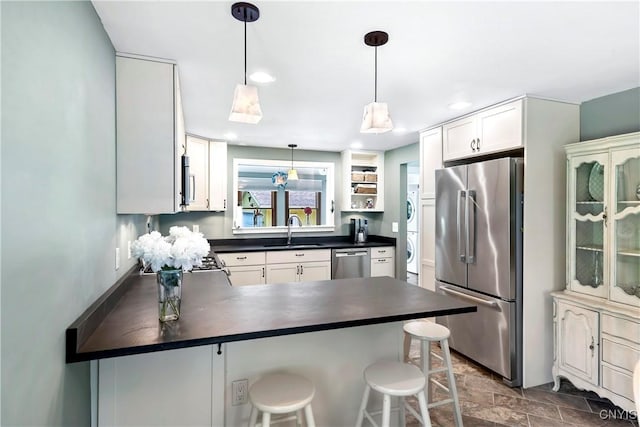 6 Orchard Rd, Skaneateles, NY 13152 - kitchen featuring stainless steel appliances, stacked washer / drying machine, dark countertops, a peninsula, and recessed lighting