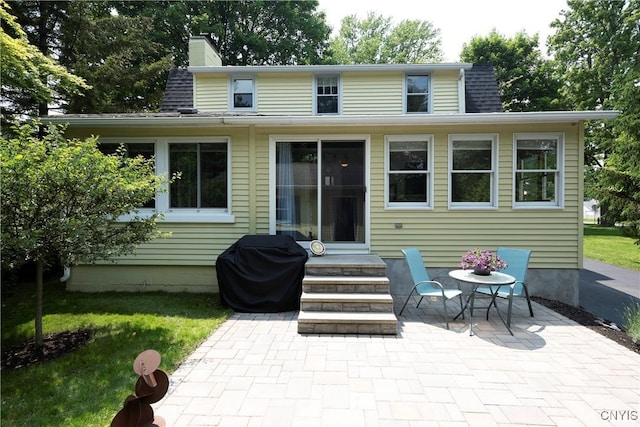 6 Orchard Rd, Skaneateles, NY 13152 - rear view of house featuring a patio, a chimney, and a lawn