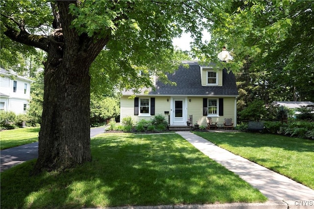 6 Orchard Rd, Skaneateles, NY 13152 - view of front facade with a front yard, a shingled roof, and a chimney