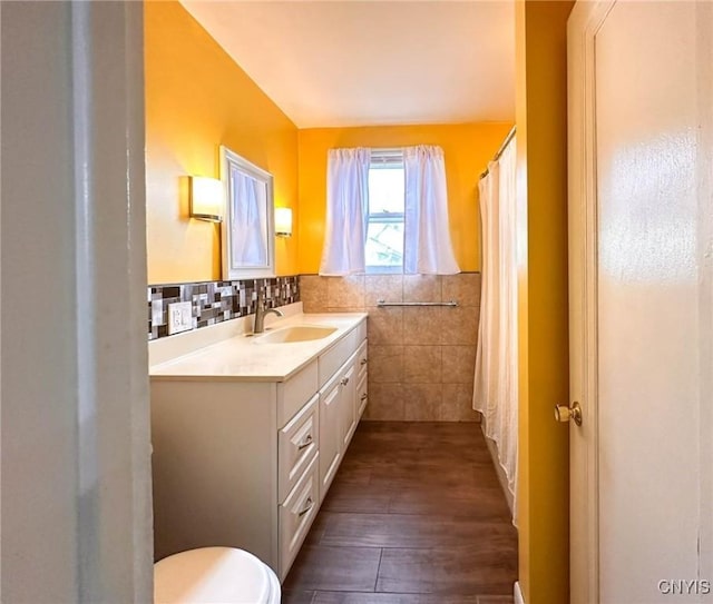 2132 Sinclair Ave, Whitestown, NY 13502 - full bathroom with vanity, wood finished floors, tile walls, a wainscoted wall, and curtained shower