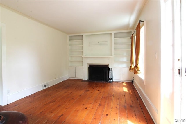 1500 Kimber Rd, Dewitt, NY 13078 - unfurnished living room with wood-type flooring, a fireplace with flush hearth, and built in shelves