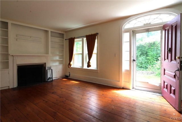 1500 Kimber Rd, Dewitt, NY 13078 - unfurnished living room with wood-type flooring, built in shelves, and a fireplace