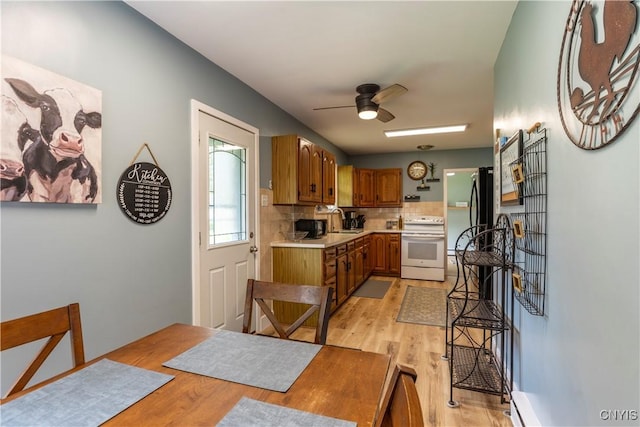 7 Bakeman St, Fulton, NY 13069 - kitchen featuring white range with electric stovetop, light countertops, brown cabinets, and light wood-type flooring