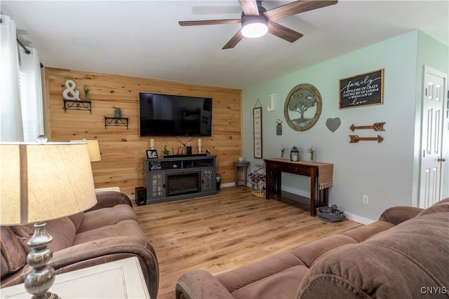 7 Bakeman St, Fulton, NY 13069 - living room with wood walls, a ceiling fan, wood finished floors, and an accent wall
