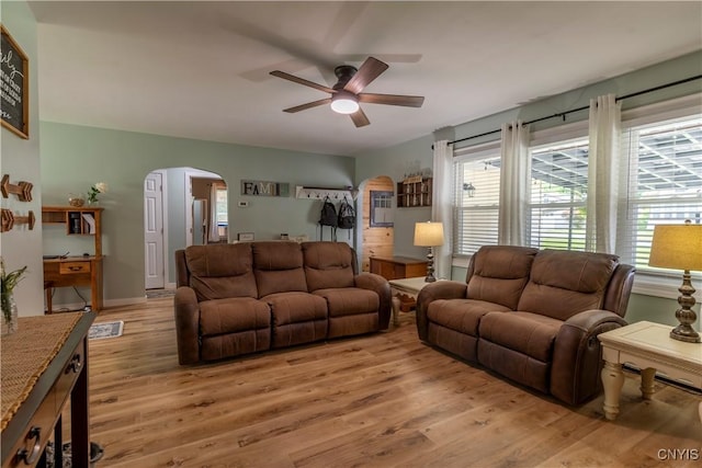 7 Bakeman St, Fulton, NY 13069 - living room with arched walkways, a ceiling fan, and light wood-style floors