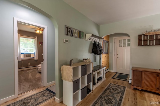 7 Bakeman St, Fulton, NY 13069 - mudroom with arched walkways, baseboard heating, cooling unit, wood finished floors, and a ceiling fan