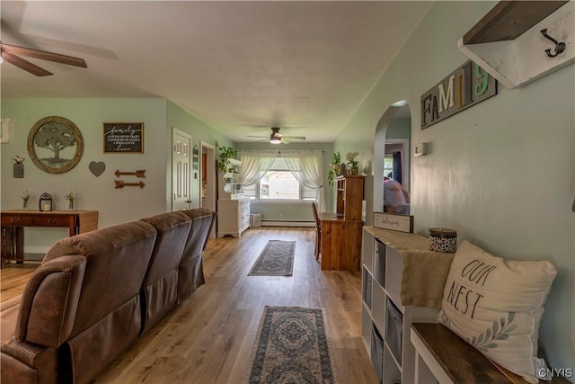 7 Bakeman St, Fulton, NY 13069 - living room with a ceiling fan, light wood-type flooring, arched walkways, and a baseboard heating unit