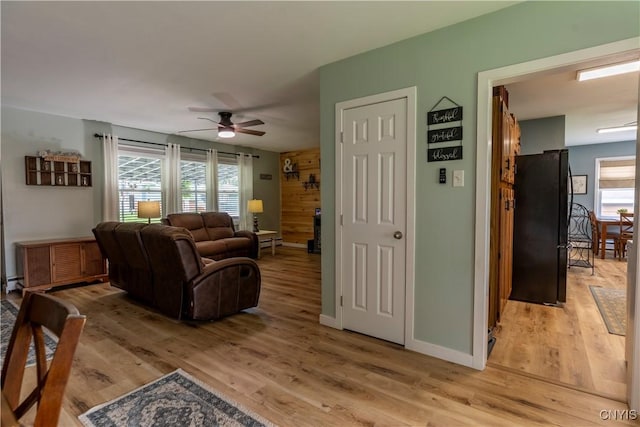 7 Bakeman St, Fulton, NY 13069 - living area with light wood-style floors, a ceiling fan, and healthy amount of natural light