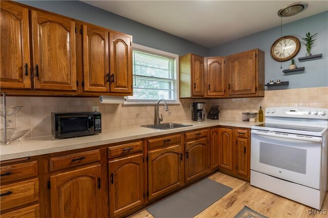 7 Bakeman St, Fulton, NY 13069 - kitchen with white range with electric stovetop, black microwave, brown cabinets, light wood-style flooring, and light countertops