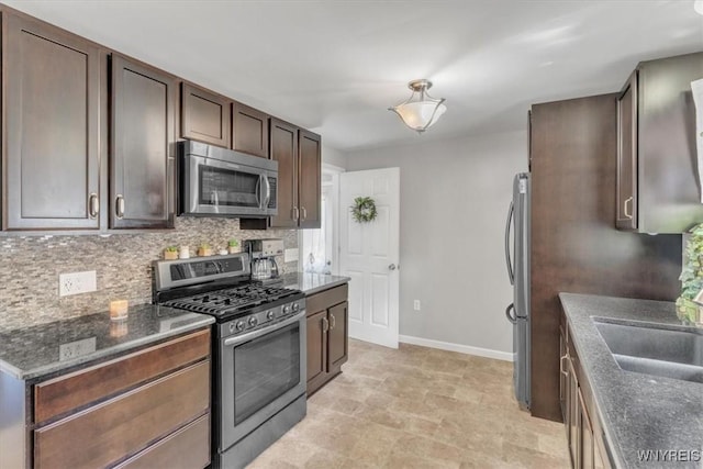 84 Kurtz Ave, Lancaster, NY 14086 - kitchen with appliances with stainless steel finishes, backsplash, dark brown cabinetry, and dark stone counters