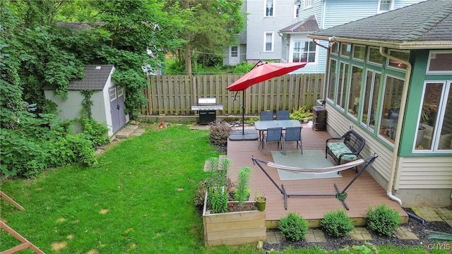 135 Strong Ave, Syracuse, NY 13210 - view of yard featuring a storage unit, a sunroom, outdoor dining area, a wooden deck, and a vegetable garden