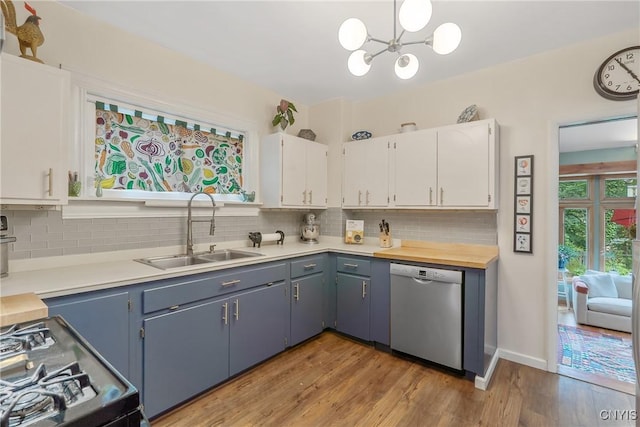 135 Strong Ave, Syracuse, NY 13210 - kitchen with dishwasher, black gas range, light countertops, a chandelier, and tasteful backsplash