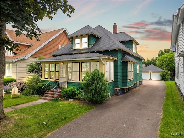 606 Tompkins St, Syracuse, NY 13204 - view of front of house with a chimney, an outbuilding, a detached garage, a shingled roof, and a front yard