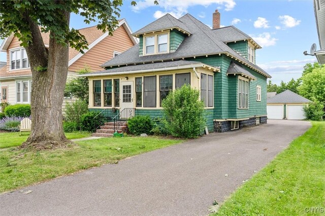 606 Tompkins St, Syracuse, NY 13204 - view of front facade featuring a chimney, a garage, an outdoor structure, roof with shingles, and a front yard