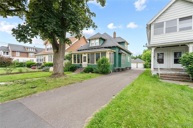 606 Tompkins St, Syracuse, NY 13204 - view of front of home with a front lawn, an outdoor structure, and a detached garage
