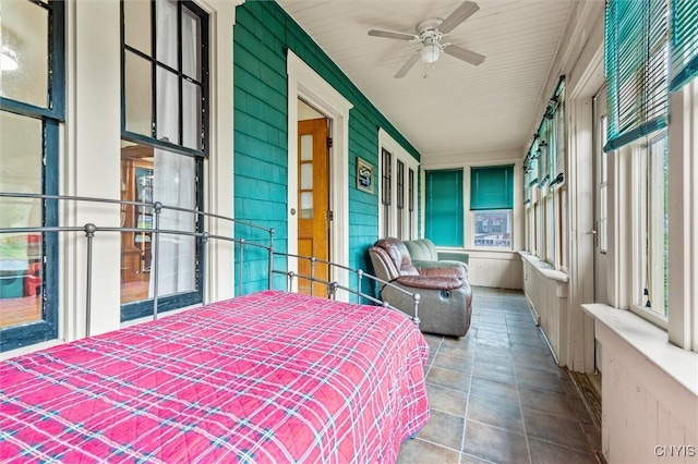 606 Tompkins St, Syracuse, NY 13204 - bedroom with multiple windows, a ceiling fan, and wooden walls
