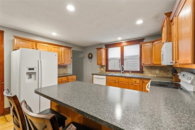 606 Tompkins St, Syracuse, NY 13204 - kitchen with white appliances, a peninsula, dark countertops, recessed lighting, and backsplash