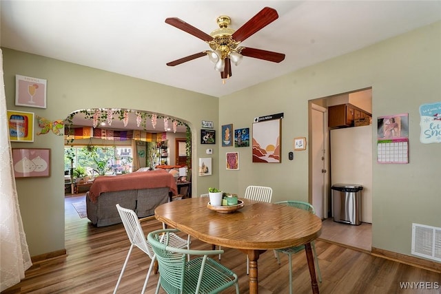 180 Lovering Ave, Buffalo, NY 14216 - dining room with light wood finished floors, arched walkways, and a ceiling fan