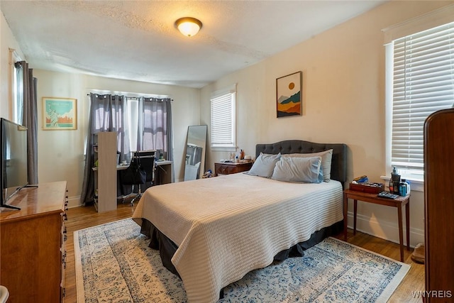 180 Lovering Ave, Buffalo, NY 14216 - bedroom featuring multiple windows, wood finished floors, and an office area
