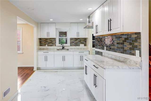 35 Kendale Rd, Cheektowaga, NY 14215 - kitchen featuring white cabinets, decorative backsplash, recessed lighting, and light marble finish flooring