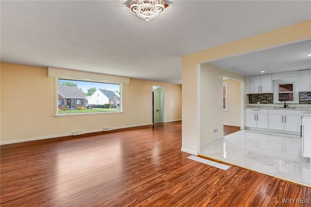 35 Kendale Rd, Cheektowaga, NY 14215 - unfurnished living room featuring light wood finished floors and a textured ceiling