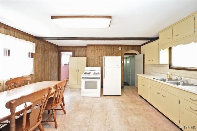 236 Weimar St, Buffalo, NY 14206 - kitchen featuring white appliances, wooden walls, light countertops, decorative backsplash, and cream cabinetry
