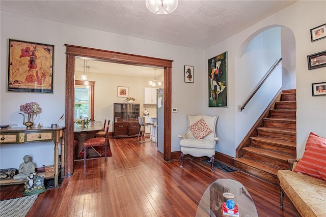 70 Field St, Rochester, NY 14620 - living room with stairs, hardwood / wood-style floors, a chandelier, a textured ceiling, and arched walkways