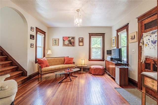 70 Field St, Rochester, NY 14620 - living room featuring arched walkways, healthy amount of natural light, hardwood / wood-style flooring, and stairs