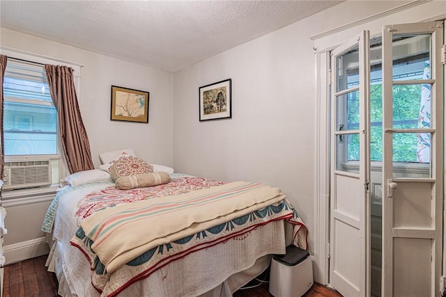 70 Field St, Rochester, NY 14620 - bedroom featuring dark wood finished floors, cooling unit, and a textured ceiling