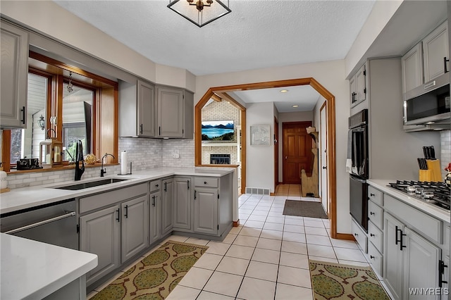 197 Shellridge Dr, Amherst, NY 14051 - kitchen featuring gray cabinets, stainless steel appliances, decorative backsplash, light countertops, and a textured ceiling