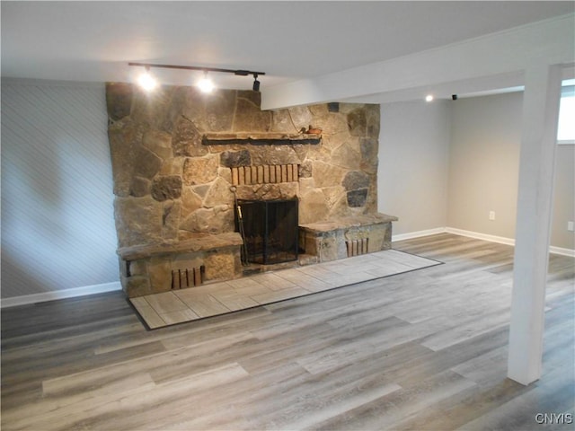 1003 Rondo Ave, Sullivan, NY 13037 - unfurnished living room featuring rail lighting, wood finished floors, and a fireplace