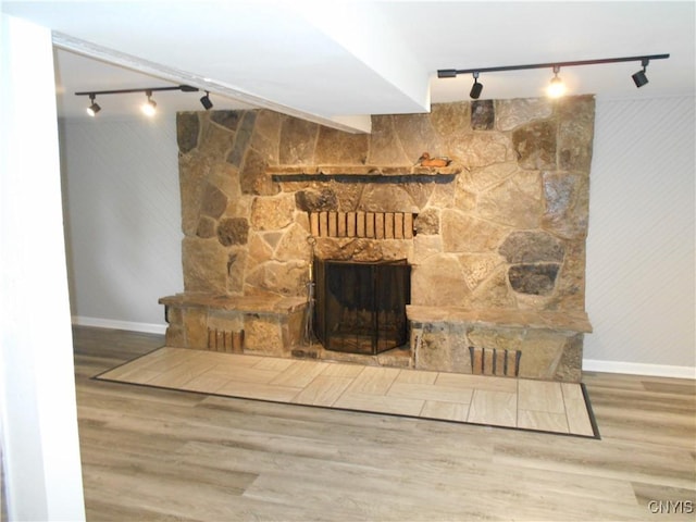 1003 Rondo Ave, Sullivan, NY 13037 - unfurnished living room with rail lighting, a stone fireplace, and wood finished floors