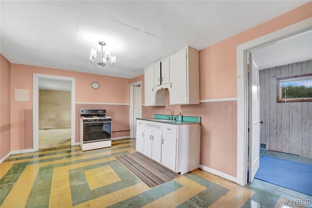 464 Rowley Rd, Cheektowaga, NY 14043 - kitchen featuring white range with gas cooktop, white cabinetry, and a chandelier