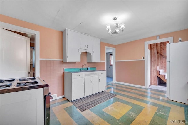 464 Rowley Rd, Cheektowaga, NY 14043 - kitchen featuring freestanding refrigerator, range with electric stovetop, white cabinetry, a chandelier, and tile walls