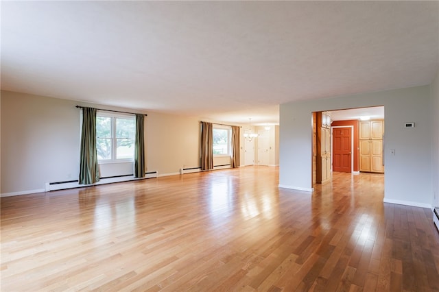 7175 Gale Rd, Lima, NY 14485 - unfurnished living room featuring a baseboard heating unit, a chandelier, plenty of natural light, and light wood-type flooring